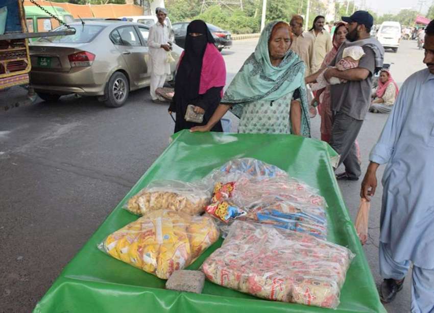 لاہور: ایک بزرگ خاتون ریڑھی پر بچوں کے کھانے کی چیزیں فروخت ..