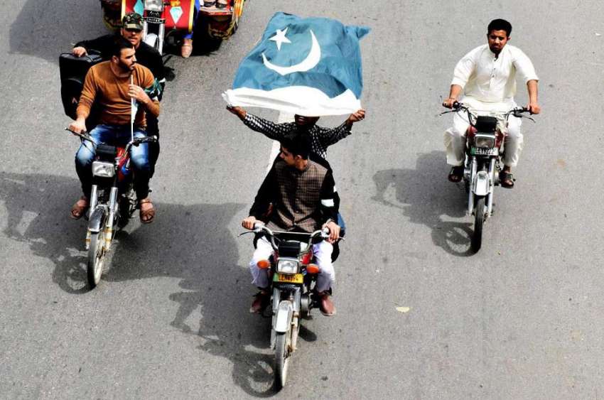 لاہور: یوم پاکستان کے موقع پر موٹر سائیکل سوار نوجوان قومی ..