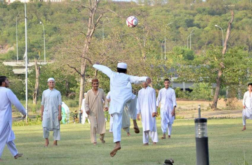 اسلام آباد: مقامی مدرسہ کے طالبعلم سڑک کنارے پارک میں فٹبال ..