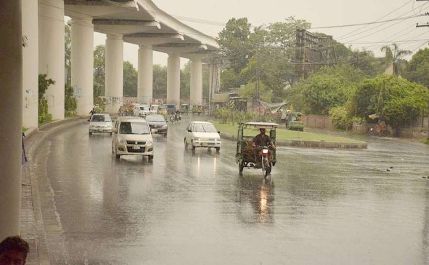 لاہور: شہر میں ہونے والی بارش کے دوران شہری اپنی منزل کی ..