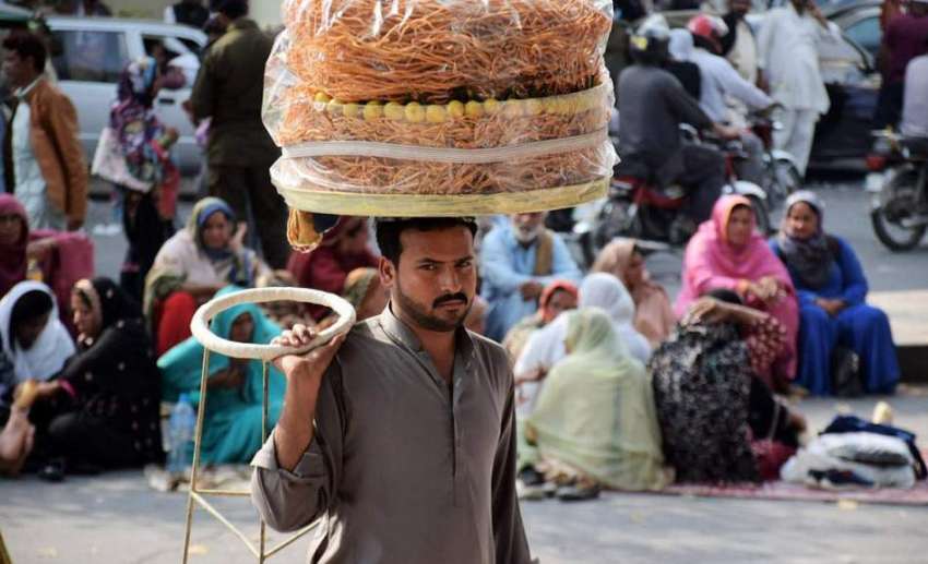 لاہور: مال روڈپر ایک شخص کھانے پینے کی اشیاء فرو خت کررہا ..