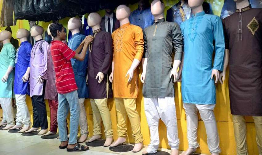 حیدر آباد: دکاندار گاہکوں کو متوجہ کرنے کے لیے کپڑے سجا رہاہے۔