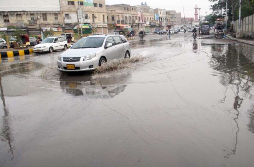 کراچی: گرو مندر روڈ پر بارش کے جمع شدہ پانی سے گاڑیاں گزررہی ..