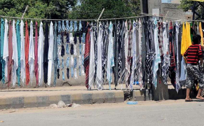 راولپنڈی: سڑک کنارے ایک دکاندار دھوپ سے بچاؤ کے رومال فروحت ..