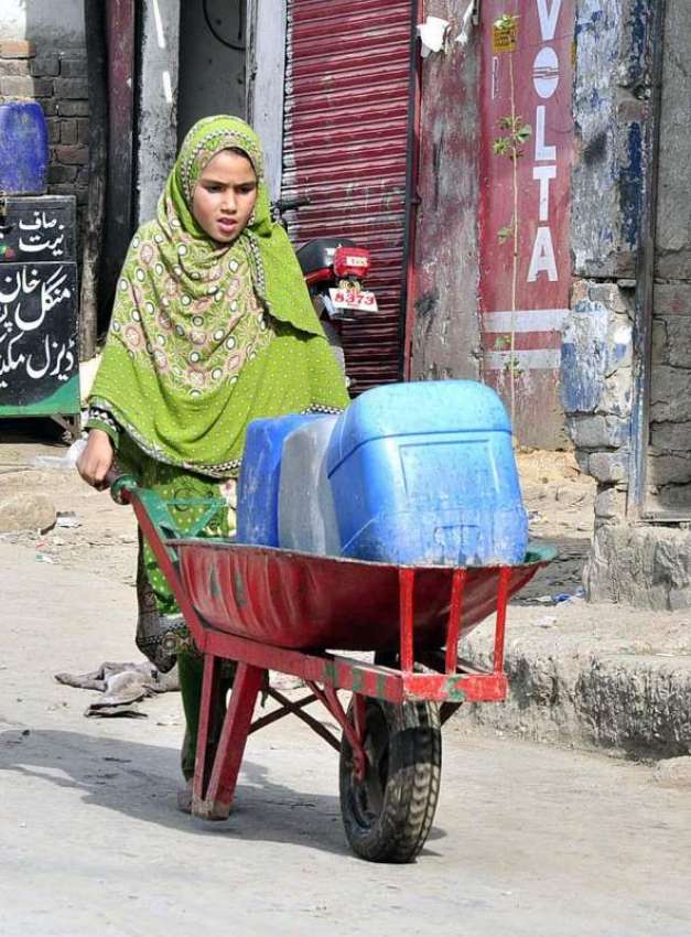 اسلام آباد: ایک لڑکی ہتھ ریڑھی پر پینے کے لیے پانی کے کین ..