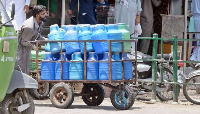 راولپنڈی: محنت کش پینے کے صاف پانی کے کین ہتھ ریڑھی پر رکھے ..