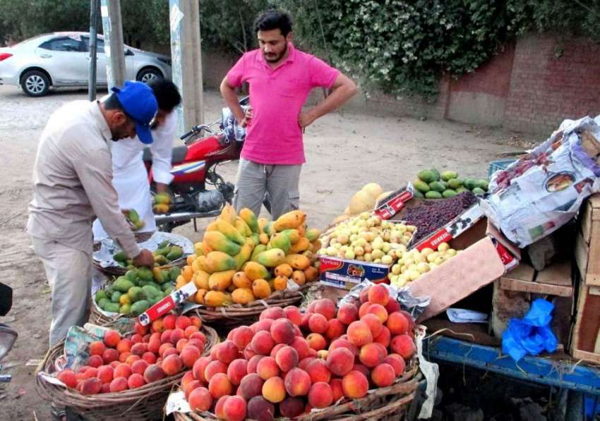 بہاولپور: شہری سڑک کنارے لگے سٹال سے تازہ پھل خرید رہاہے۔