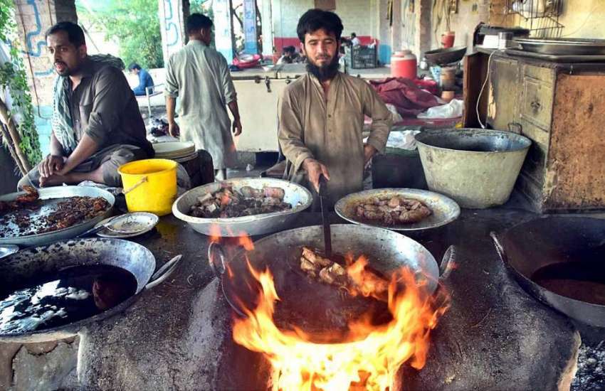پشاور: دکاندار گاہکوں کو متوجہ کرنے کے لیے مچھلی فرائی کررہا ..