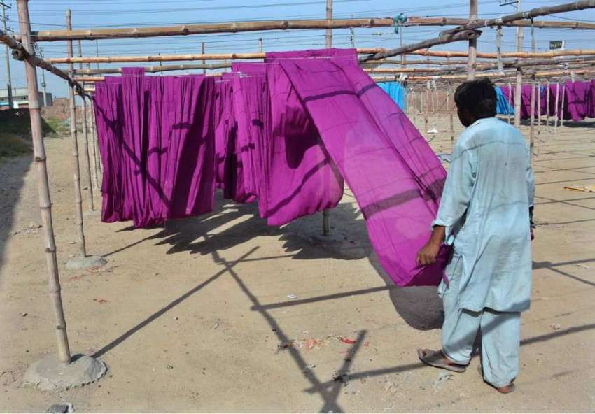 فیصل آباد: محنت کش کپڑا خشک کرنے کے لیے دھوپ میں پھیلا رہا ..