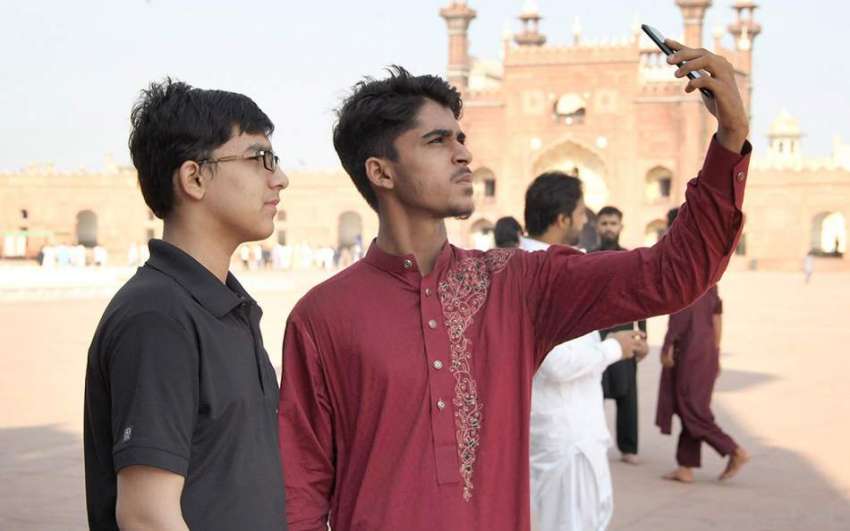 لاہور: بادشاہی مسجد کے احاطے میں نوجوان سیلفی لے رہے ہیں۔