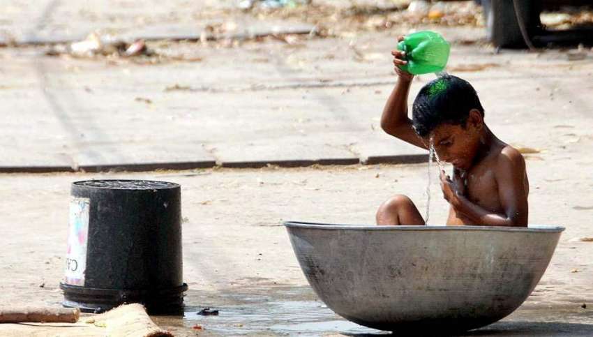 راولپنڈی: خانہ بدوش بچہ گرمی کی شدت سے بچنے کے لیے نہا رہا ..