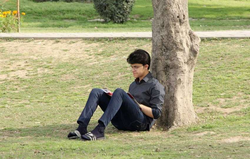 لاہور: جیلانی پارک میں ایک نوجوان درخت کے سائے تلے کتاب بینی ..