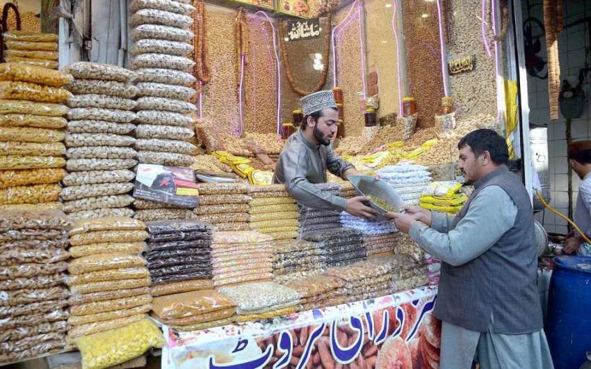پشاور: کینٹ بازار میں گاہک کو راغب کرنے کے لئے ایک دکاندار ..