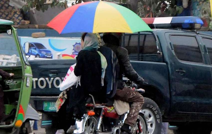 راولپنڈی: ایک فیملی بارش سے بچنے کے لیے چھتری تھامے بائیک ..