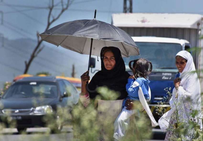 اسلام آباد: خاتون نے گرمی کی شدت سے بچنے کے لیے چھتری تان ..