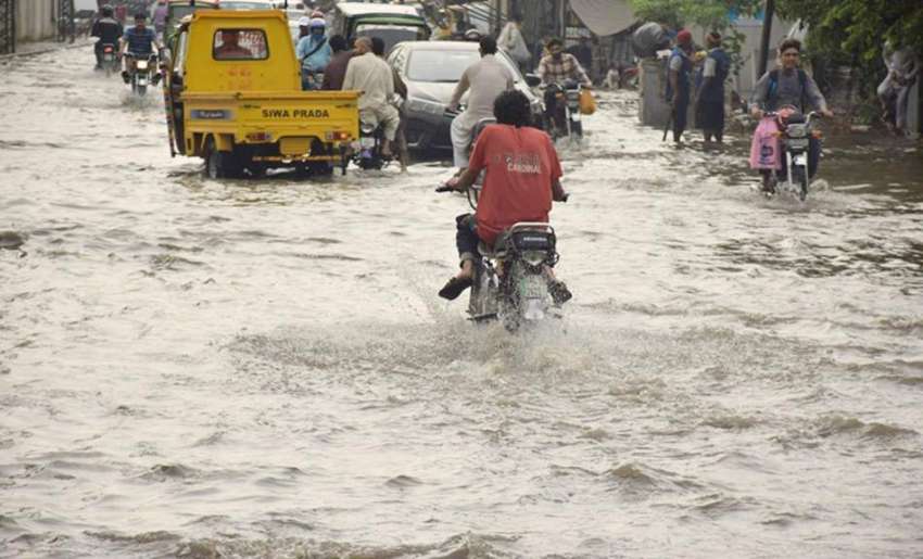 لاہور: شہر میں ہونے والی بارش کے بعد ایک شاہراہ پانی میں ..