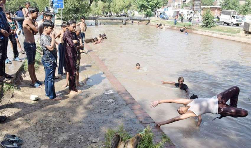 لاہور: گرمی کی شدت کم کرنے کے لیے بچے نہر میں نہا رہے ہیں، ..