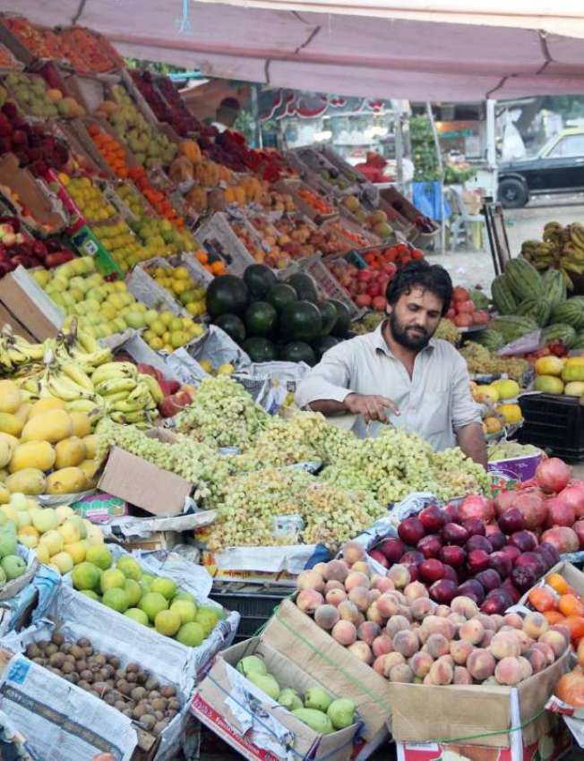 کراچی: ایک دکاندار سڑک کنارے پھل فروخت کر رہا ہے