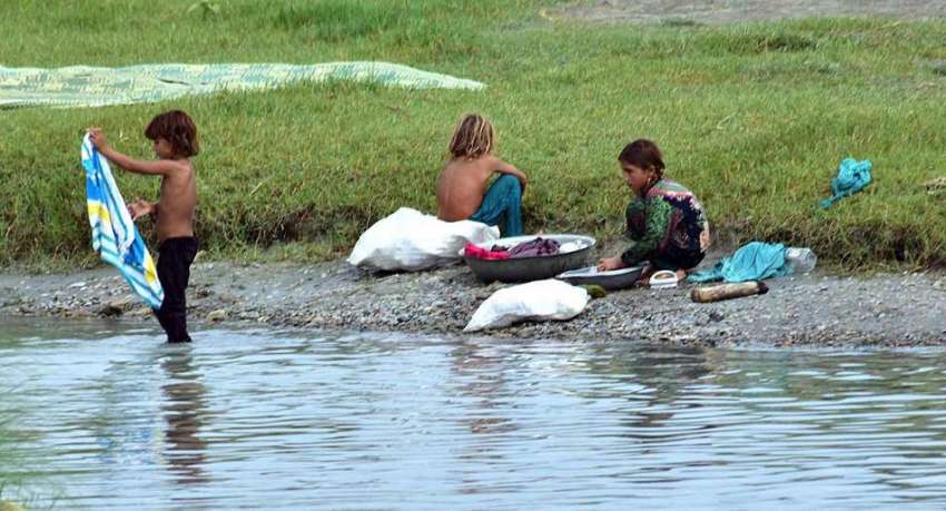 پشاور: خانہ بدوش لڑکیاں دریائے ناگومان کے کنارے کپڑے دھو ..