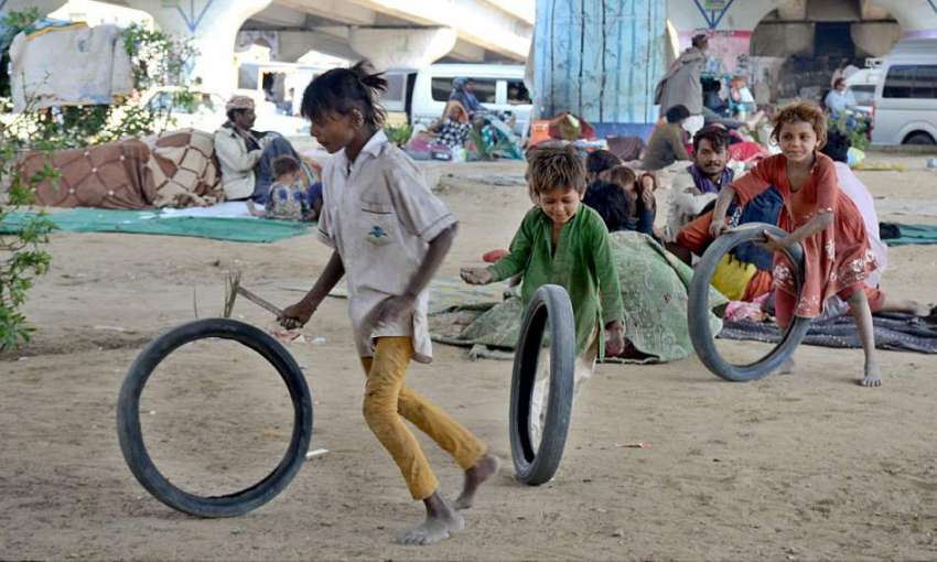 کراچی: خانہ بدوش بچے سڑک کے کنارے کھیل رہے ہیں۔
