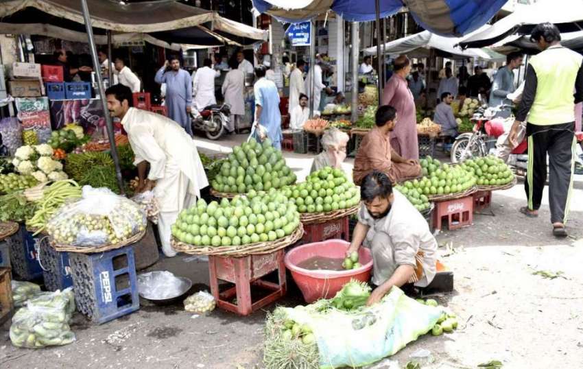 فیصل آباد: دکاندار فروخت کے لیے آم دھونے میں مصروف ہے۔