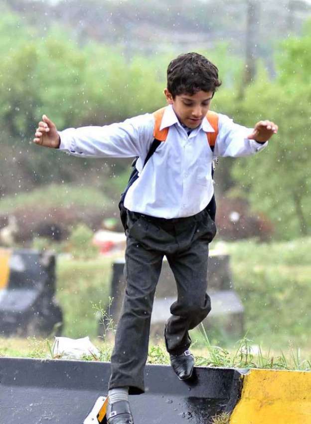 اسلام آباد: سکول سے چھٹی کے بعد بچے بارش سے لطف اندوز ہو رہا ..