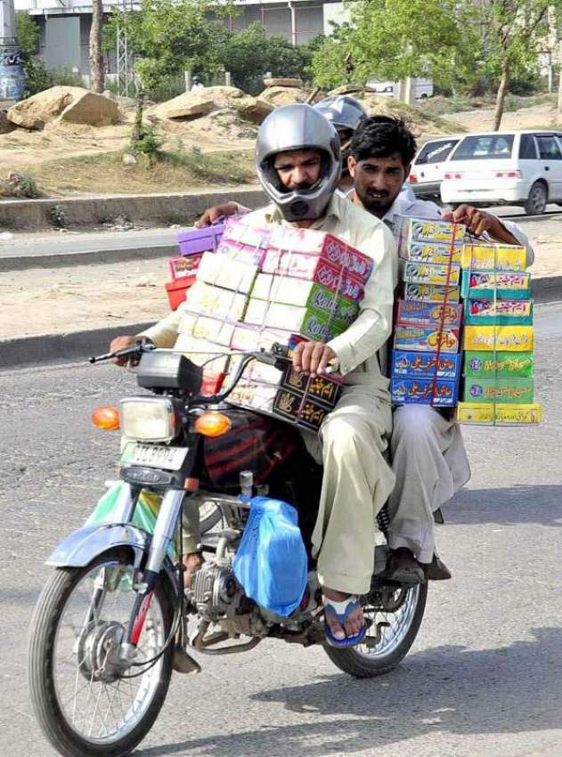 راولپنڈی: موٹر سائیکل سوار چوڑیوں کے ڈبے اٹھائے جا رہے ہیں۔