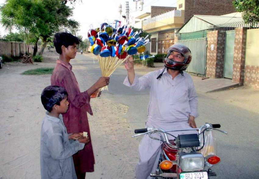 بہاولپور: موٹر سائیکل سوار بچوں کے لیے کھلونے خرید رہا ہے۔