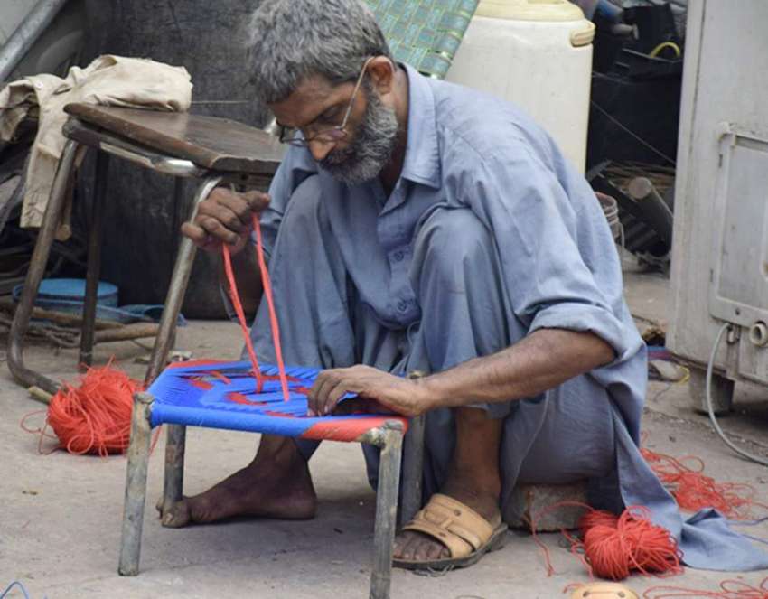لاہور: ایک محنت کش نائیلون سے پیڑھی بن رہا ہے۔