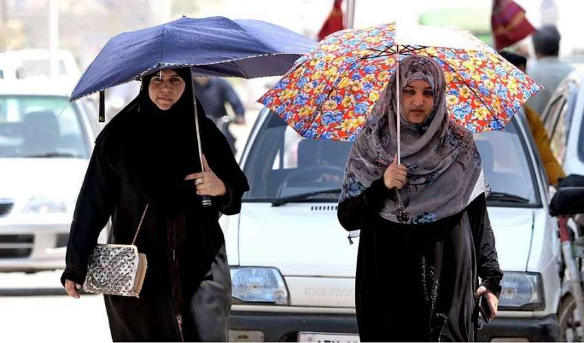 راولپنڈی: دھوپ سے بچنے کے لیے خواتین چھتری تانے جا رہی ہیں۔