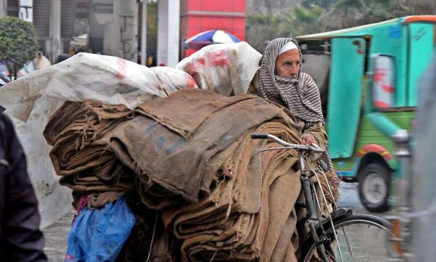 راولپنڈی: معمر محنت کش بارش کے دوران سائیکل پر خالی بوریاں ..