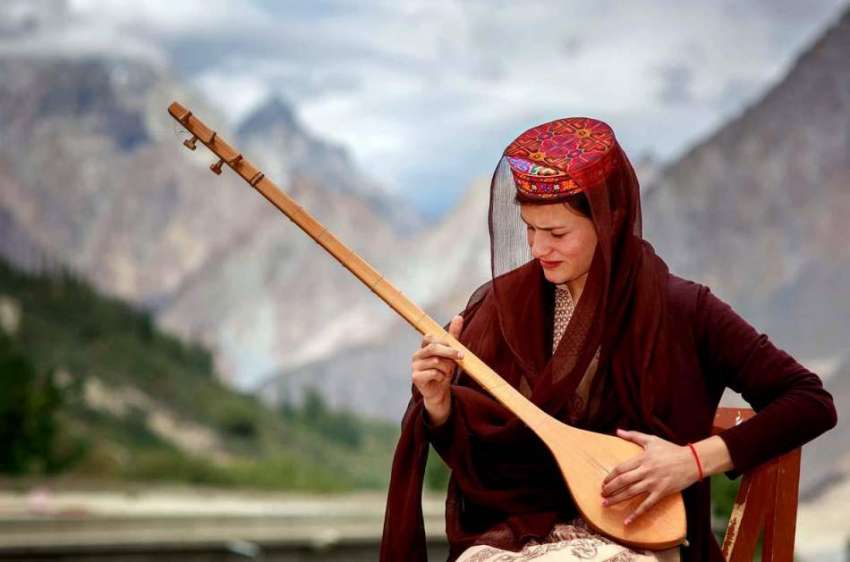 ہنزہ: مقامی خاتون رباب بجا رہی ہے۔