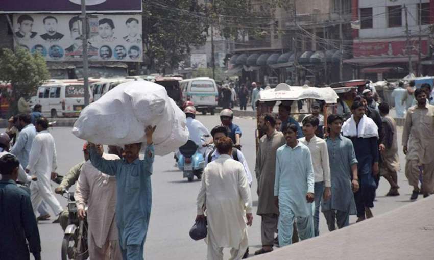 لاہور: ایک شخص بھاری سامان اٹھائے جا رہا ہے۔