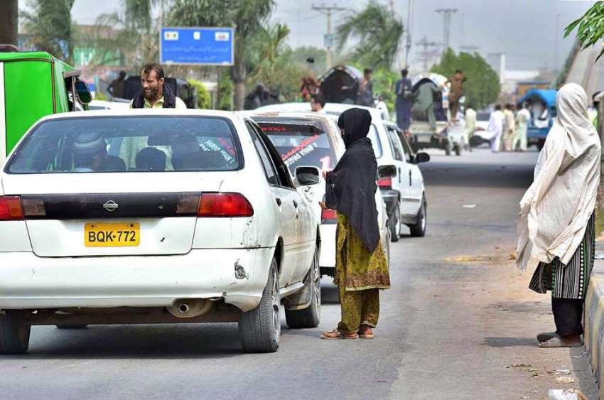 پشاور: رنگ روڈ چوک پر ایک خانہ بدوش لڑکی گاڑی ڈرائیوروں سے ..