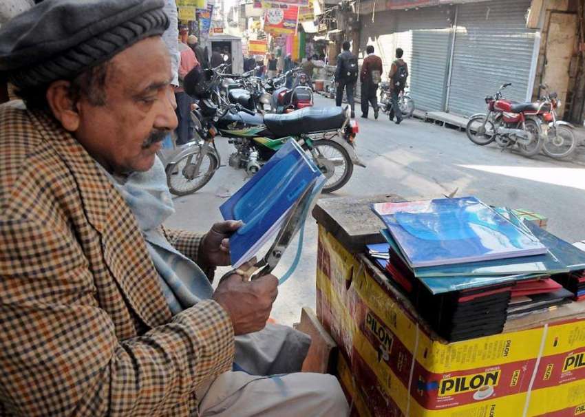 راولپنڈی: اردو بازار میں ایک دکاندار بائنڈنگ کے کام میں ..