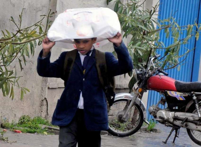 راولپنڈی: بارش سے بچنے کے لیے ایک طالبعلم سر پر پلاسٹک بیک ..