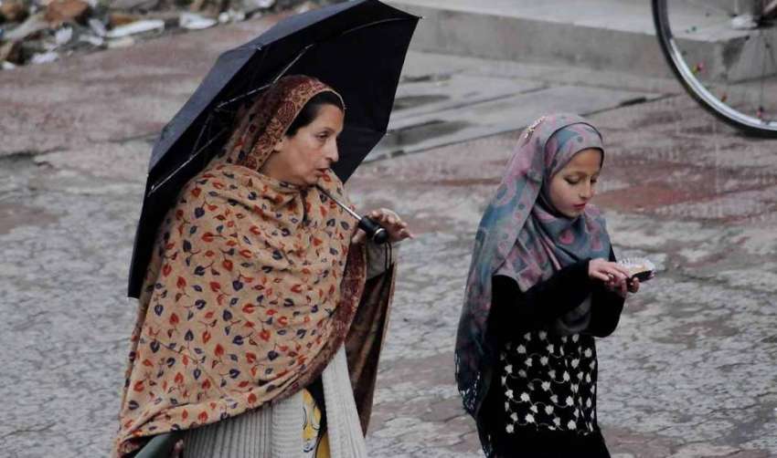 اسلام آباد: بارش سے بچنے کے لیے خاتون نے چھتری تان رکھی ہے۔