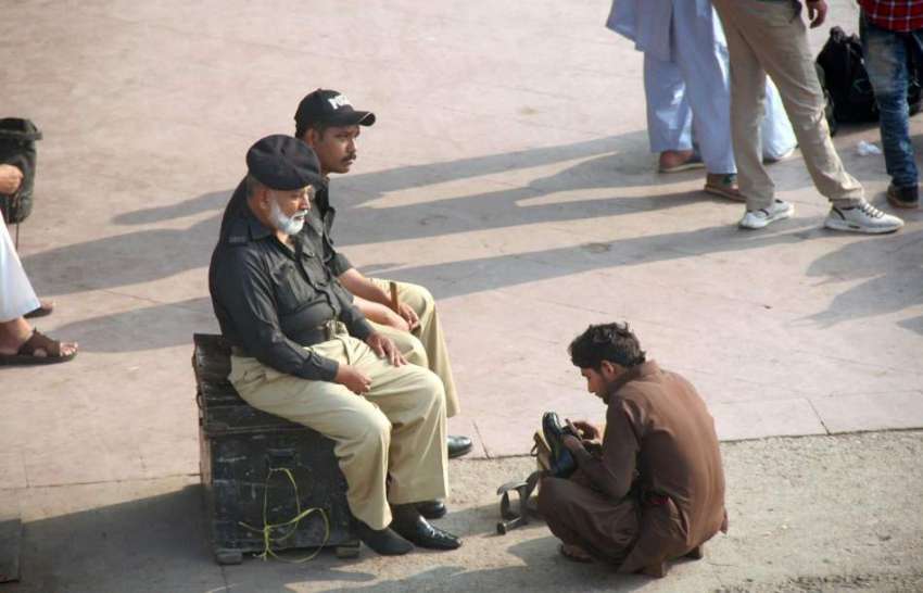 کراچی: نوجوان پولیس اہلکاروں کے بوٹ پالش کر رہا ہے۔