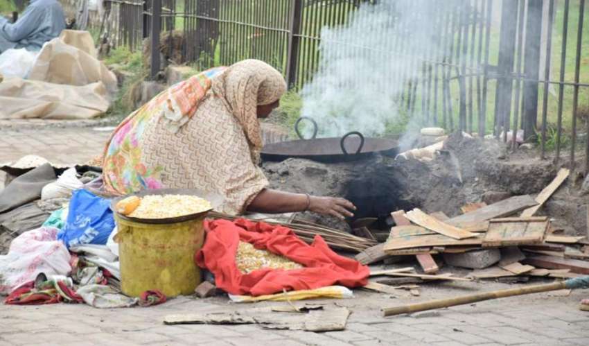 لاہور: ایک محنت کش خاتون بھٹی پر گرم کرنے کے لیے آگ جلا رہی ..