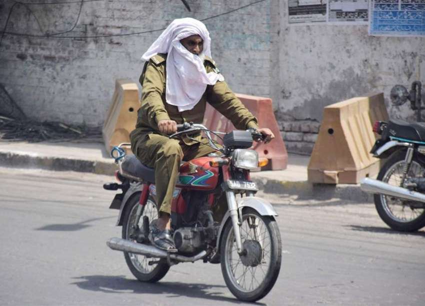 لاہور: موٹر سائیکل سوار پولیس اہلکار گرمی کی شدت سے بچنے ..