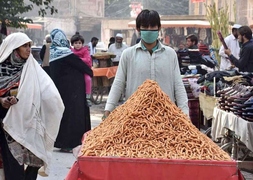 پشاور: ریڑھی بان کھانے پینے کی اشیاء فروخت کررہا ہے۔