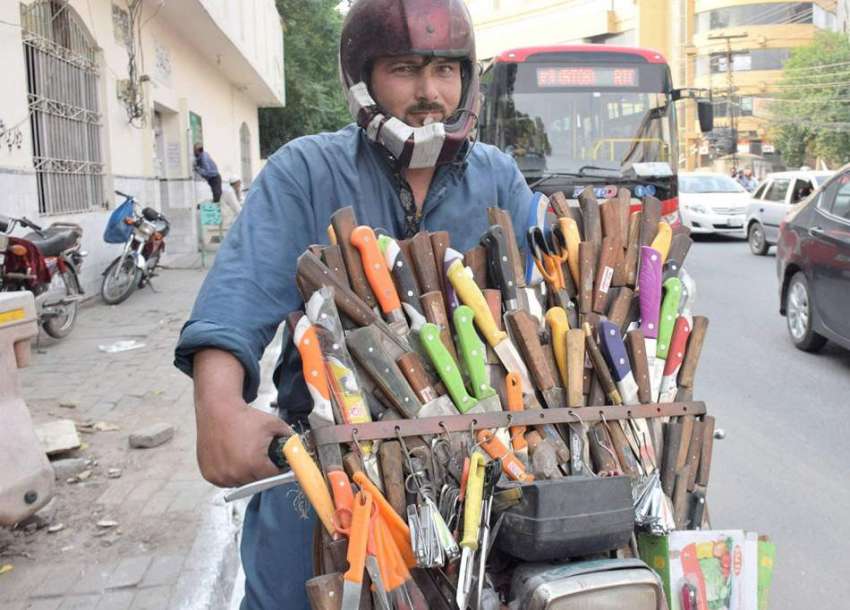 لاہور: ایک شخص موٹر سائیک پر چھریاں فروخت کررہا ہے۔