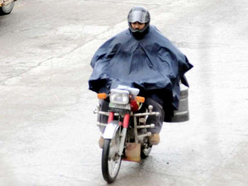اسلام آباد: موٹر سائیکل سوار بارش سے بچنے کے لیے پلاسٹک شیٹ ..