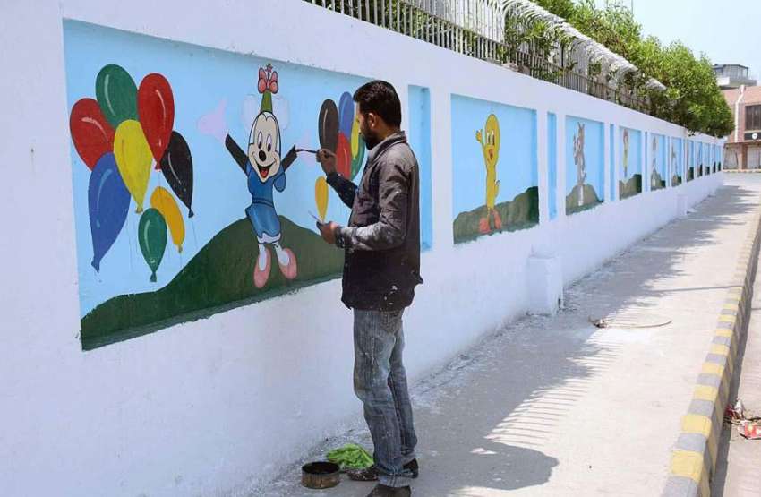 فیصل آباد: عید الفطر کی آمد کے موقع پر ایک آرٹسٹ دیوار پر ..