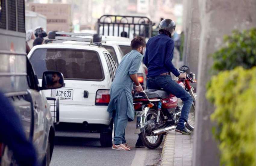 راولپنڈی: مری روڈ پر ٹریف جام کے باعث ایک شخص اپنی موٹر سائیکل ..