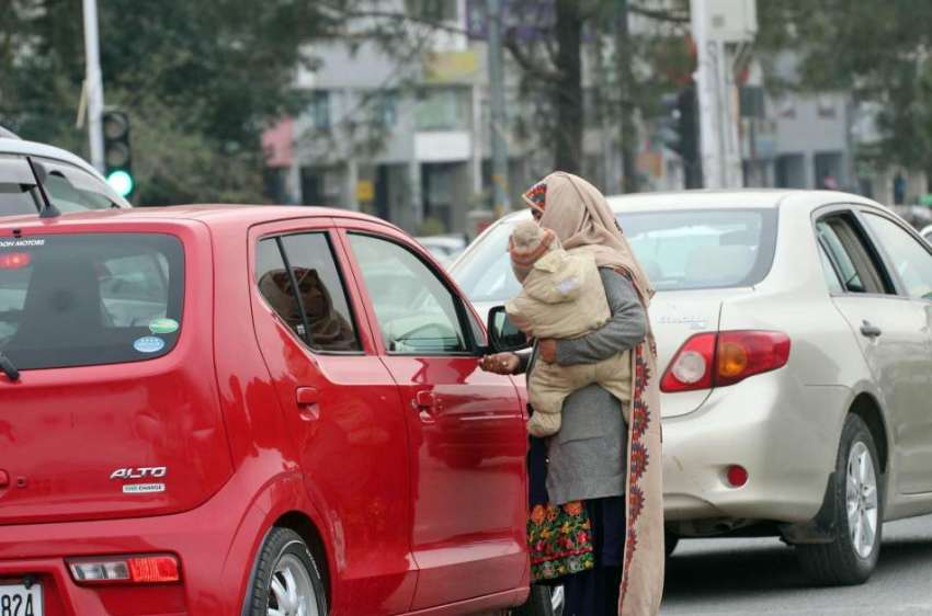 اسلام آباد: ایک خاتون ٹریفک سگنل پر بھیک مانگ رہی ہے۔