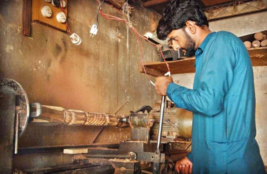 اسلام آباد: کمسن کارپینٹر اپنی ورکشاپ میں فرنیچر بنانے میں ..