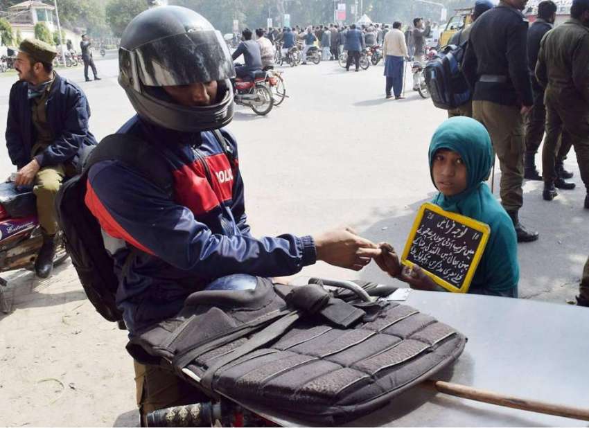 لاہور: پولیس اہلکار مال روڈ پر ایک بچی کو بھیک دے رہا ہے۔