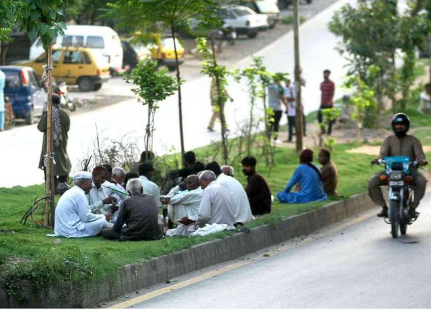 اسلام آباد: معمر شہری سڑک کنارے گرین بیلٹ پر بیٹھے تاش کھیل ..
