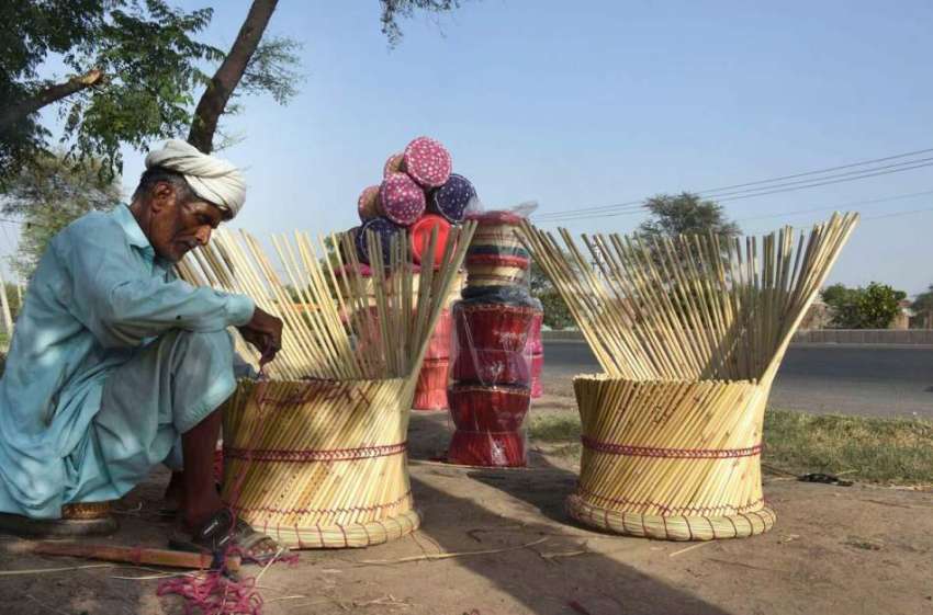 لاہور: محنت کش روایتی انداز سے (کانے) کی کرسیاں بنا رہا ہے۔